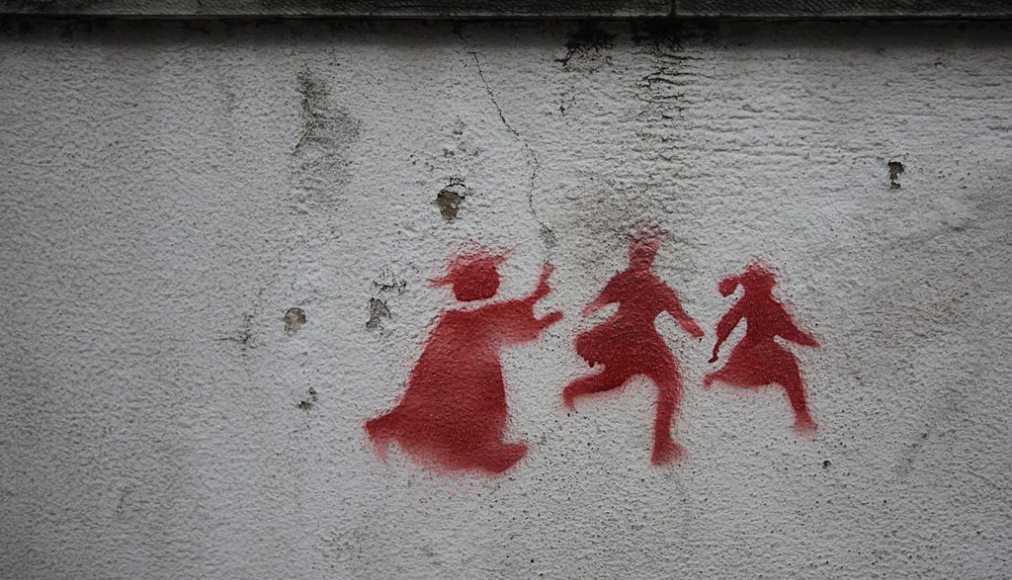 Graffiti sur un mur de Lisbonne montrant un prêtre pourchassant deux enfants. Graffiti sur un mur de Lisbonne montrant un prêtre pourchassant deux enfants. / © Wikimedia Commons/Milliped/CC-BY-3.0