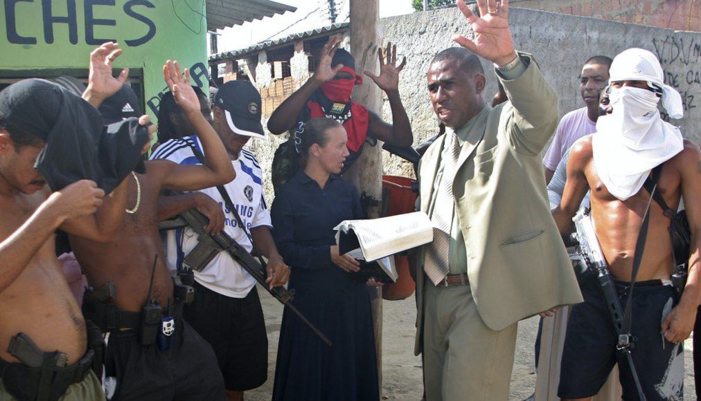 Sur cette photo prise le 31 mars 2009, le pasteur Andre Assis, au centre, prie avec des trafiquants de drogue présumés dans un bidonville de Rio de Janeiro. Sur cette photo prise le 31 mars 2009, le pasteur Andre Assis, au centre, prie avec des trafiquants de drogue présumés dans un bidonville de Rio de Janeiro. / Keystone
