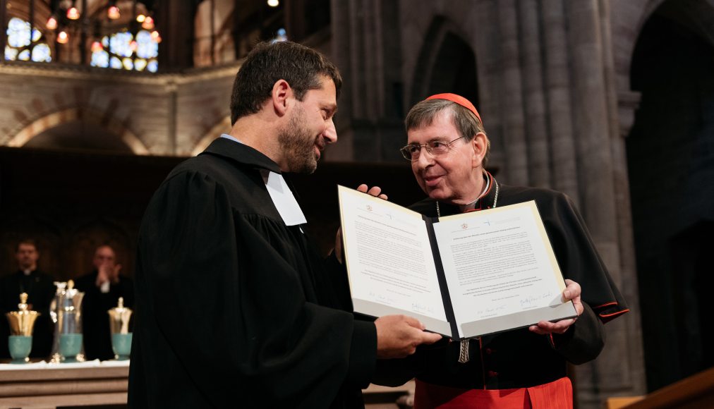 Gottfried Locher et le cardinal Kurt Koch tenant la déclaration d'intention proposant de commencer un dialogue officiel entre les protestants d'Europe et le Vatican. Elle a été signée à la cathédrale de Bâle le 16 septembre dernier. Gottfried Locher et le cardinal Kurt Koch tenant la déclaration d'intention proposant de commencer un dialogue officiel entre les protestants d'Europe et le Vatican. Elle a été signée à la cathédrale de Bâle le 16 septembre dernier. / © FEPS/Olivier Hochstrasser